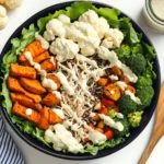Chicken power bowl with roasted sweet potatoes, broccoli, cauliflower, wild rice, and creamy cilantro-lime dressing – a healthy and protein-packed meal.