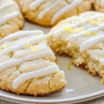 Keto lemon pound cookies on a plate with one broken open, showing soft texture and lemon glaze.