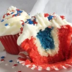 Fireworks Funfetti Cupcake with red, white, and blue layers and vanilla frosting topped with patriotic star sprinkles