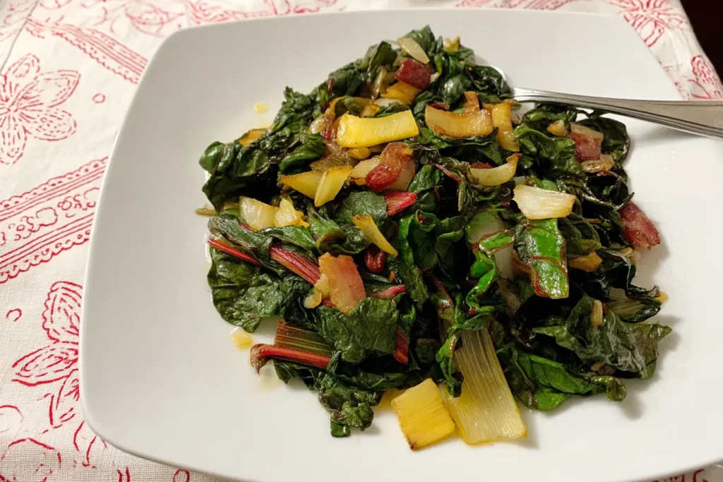 Sautéed rainbow chard with garlic, lemon, and caramelized stems served on a white plate