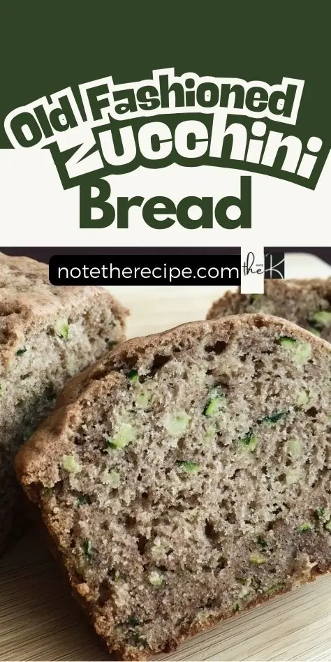 Sliced old fashioned zucchini bread loaf showing moist crumb and zucchini flecks on a wooden board