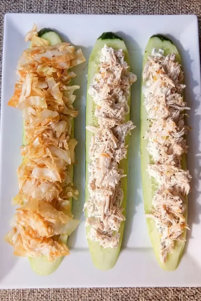 Cucumber boats filled with shredded chicken salad on white plate for easy keto snacking