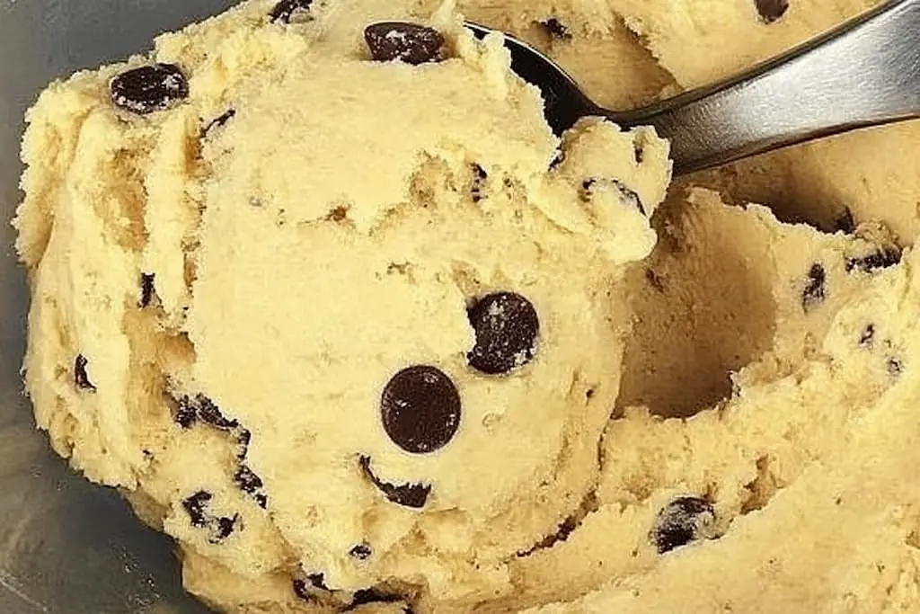 Spoonful of safe edible cookie dough with chocolate chips showing creamy texture ready to eat